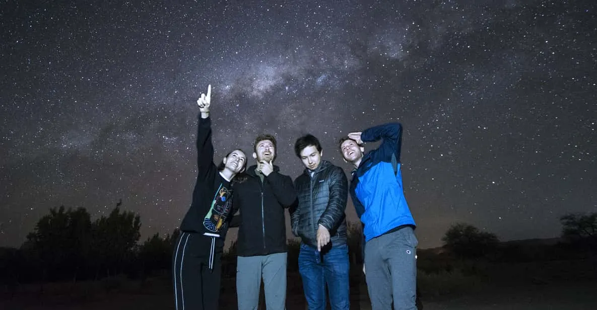 A traveler looking through a telescope under the Milky Way on an Atacama Desert stargazing tour near San Pedro de Atacama, Chile