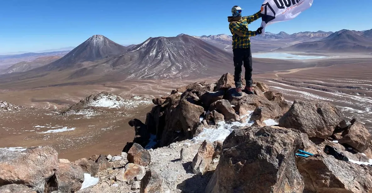 Hikers on the snow-dusted summit ridge of Cerro Toco on an Atacama Desert trekking tour at 5,604 meters in Chile